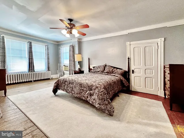 a bedroom with a large bed chandelier and a window
