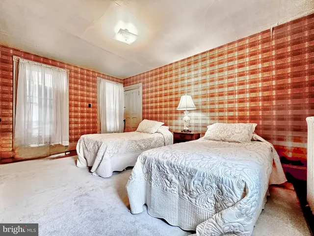 a bedroom with two beds and a night stand