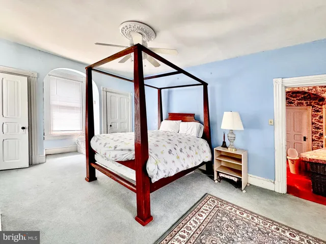 a bedroom with a bed lamp and a dresser