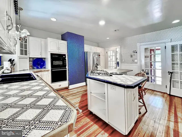 a kitchen with stainless steel appliances kitchen island granite countertop a sink and a refrigerator