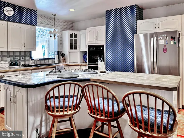 a kitchen with stainless steel appliances granite countertop a sink and a dining table
