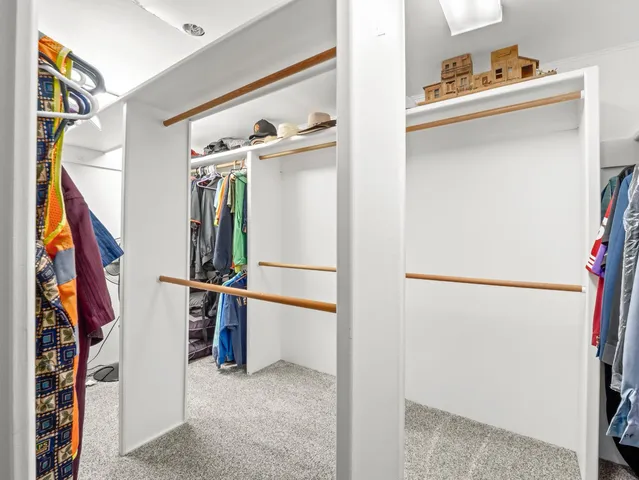 a view of walk in closet with clothes and shoes