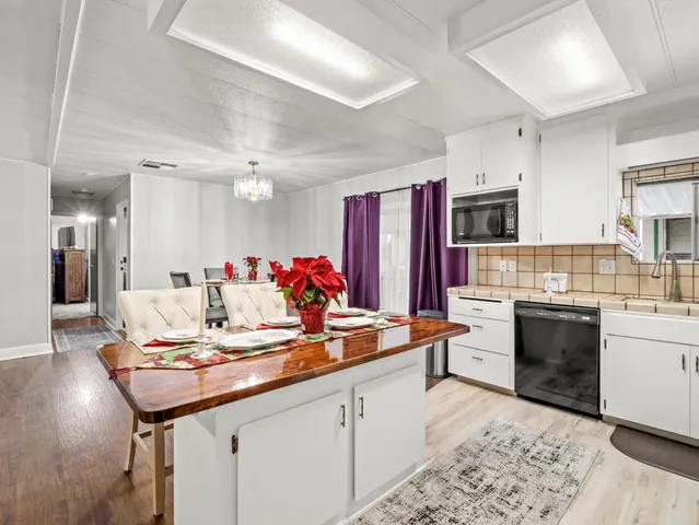 a kitchen with granite countertop a sink cabinets and stainless steel appliances