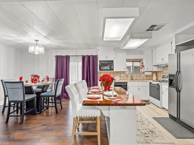 a dining room with furniture and kitchen view