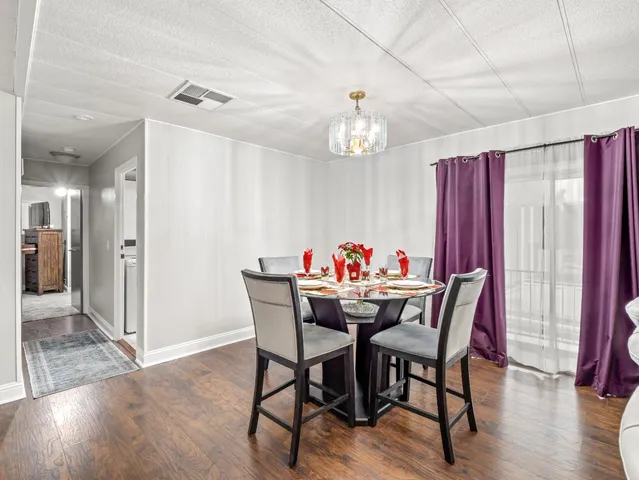 a view of a dining room with furniture wooden floor and a chandelier