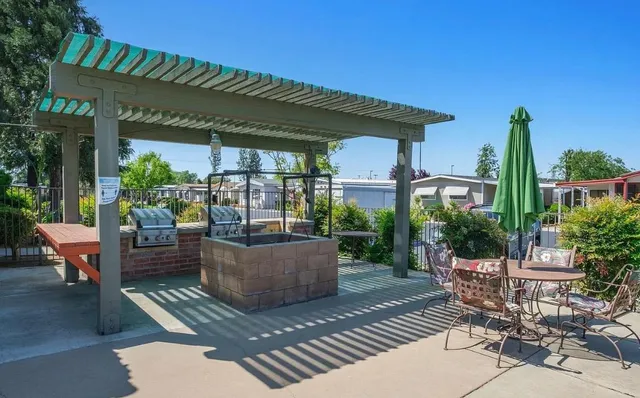 a patio with patio a table and chairs and potted plants