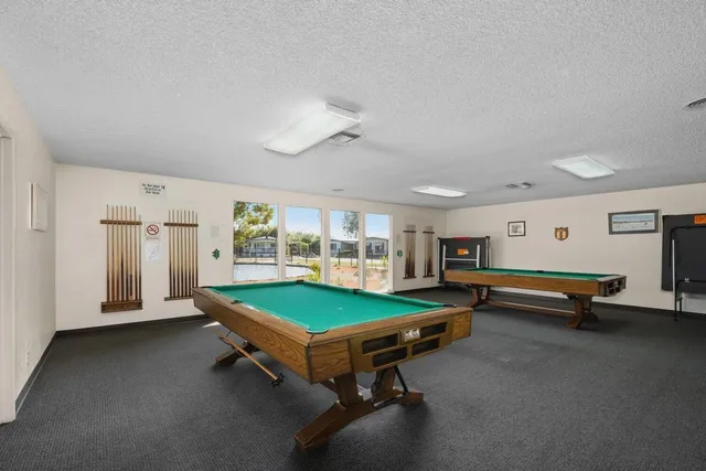 a room with pool table and windows