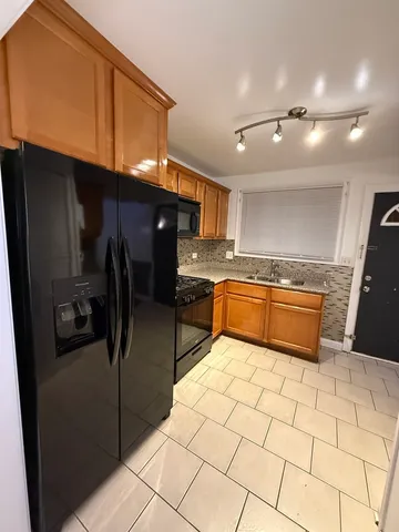 a kitchen with stainless steel appliances granite countertop a sink a stove a refrigerator and a microwave