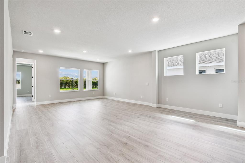 11743 Full Moon Loop Parrish, FL 34219 - Photo 11 of 42 an empty room with wooden floor and windows