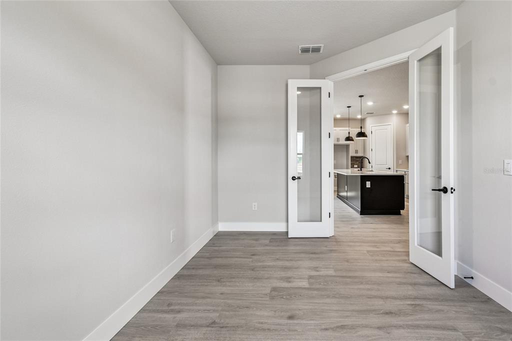 11743 Full Moon Loop Parrish, FL 34219 - Photo 16 of 42 a view of a hallway with wooden floor and a cabinet