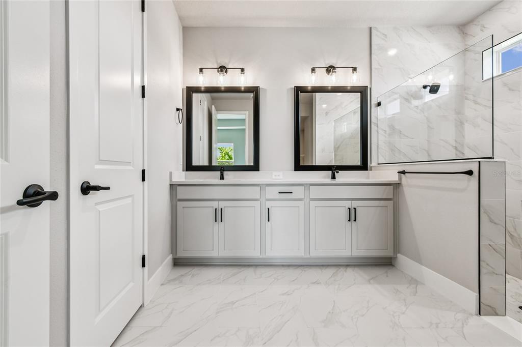 11743 Full Moon Loop Parrish, FL 34219 - Photo 20 of 42 a bathroom with a sink a mirror and a shower