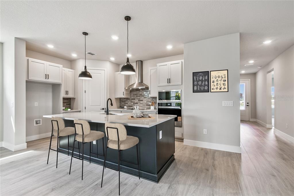 11743 Full Moon Loop Parrish, FL 34219 - Photo 3 of 42 a large kitchen with a table and chairs