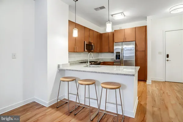 a kitchen with kitchen island granite countertop a sink cabinets and wooden floor