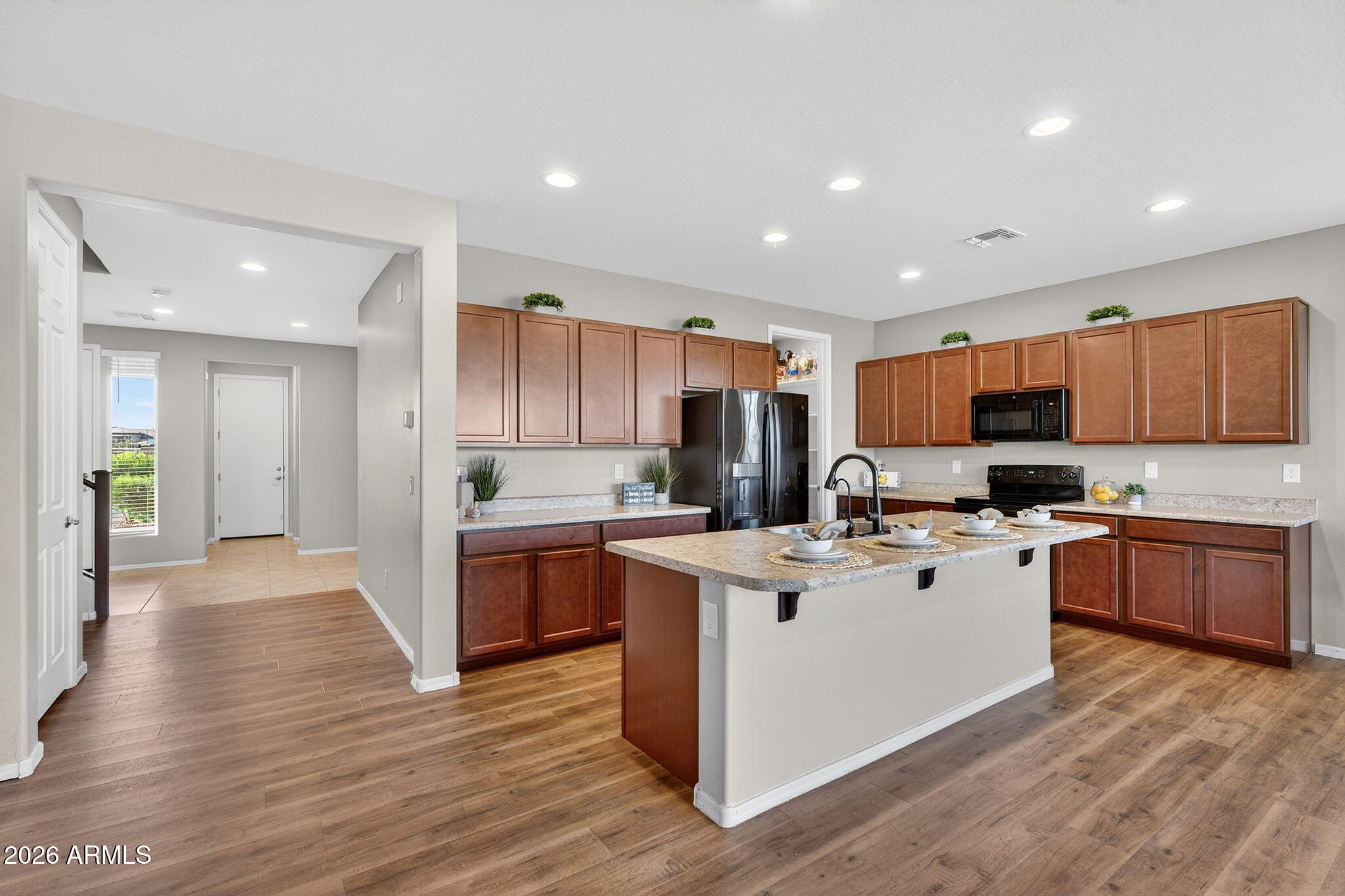 10061 Cotton Road Florence, AZ 85132 - Photo 4 of 53 a kitchen with stainless steel appliances kitchen island granite countertop a stove top oven a sink a refrigerator and white cabinets with wooden floor