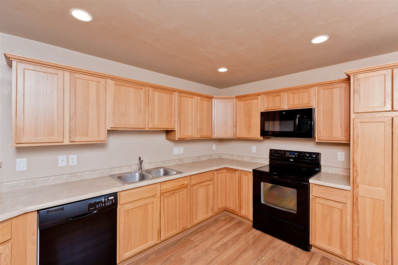 3138 Dublin Way Grand Junction, CO 81504 - Photo 11 of 42 a kitchen with stainless steel appliances granite countertop a stove a sink and a refrigerator