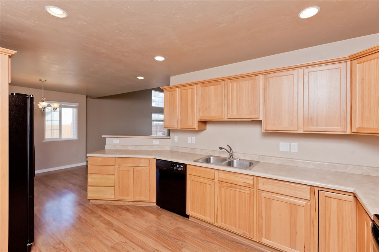 3138 Dublin Way Grand Junction, CO 81504 - Photo 12 of 42 a kitchen with stainless steel appliances granite countertop a sink and cabinets with wooden floor