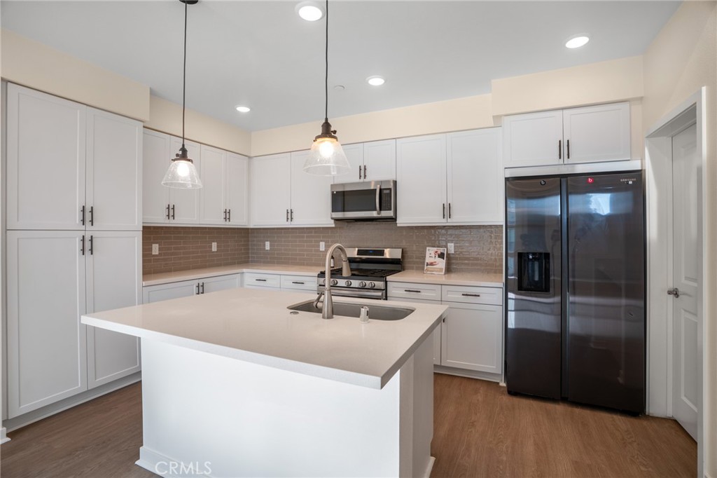 11055 Wander Drive Rancho Cucamonga, CA 91730 - Photo 9 of 28 a kitchen with kitchen island a sink stainless steel appliances and cabinets
