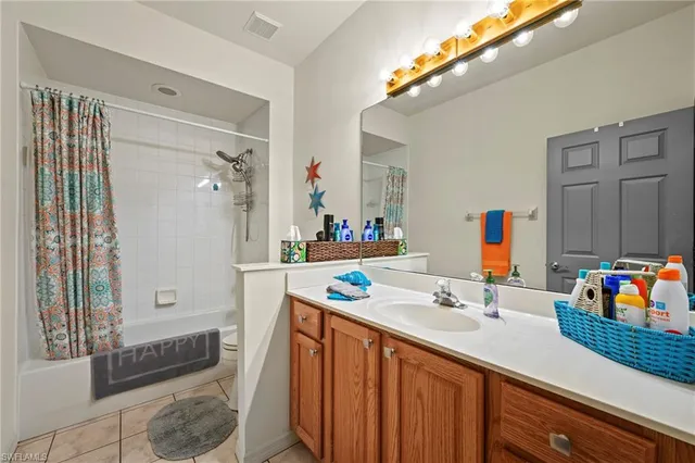 a bathroom with a sink vanity granite tub shower and a mirror