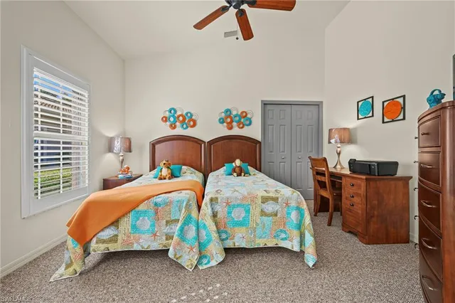 a bedroom with two beds and a desk