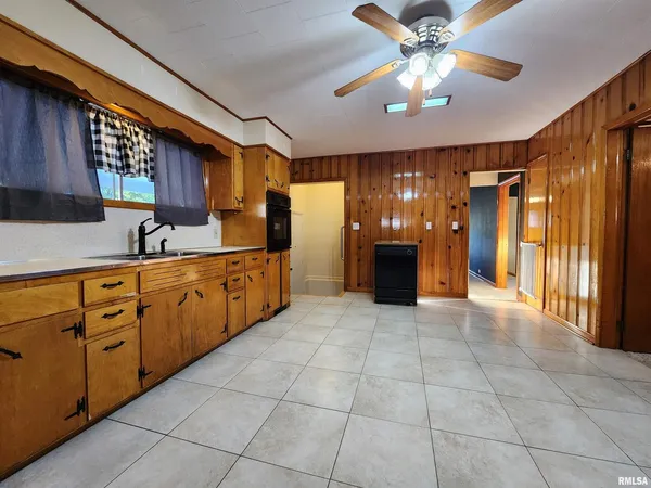 a large kitchen with a large counter space a sink stainless steel appliances and cabinets
