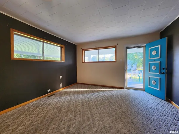 a view of an empty room with window and stairs