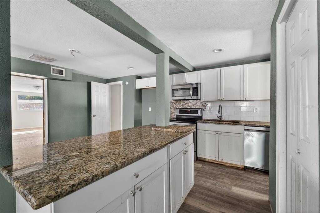842 Channing Road Lakeland, FL 33805 - Photo 8 of 27 a kitchen with stainless steel appliances granite countertop a sink stove and refrigerator