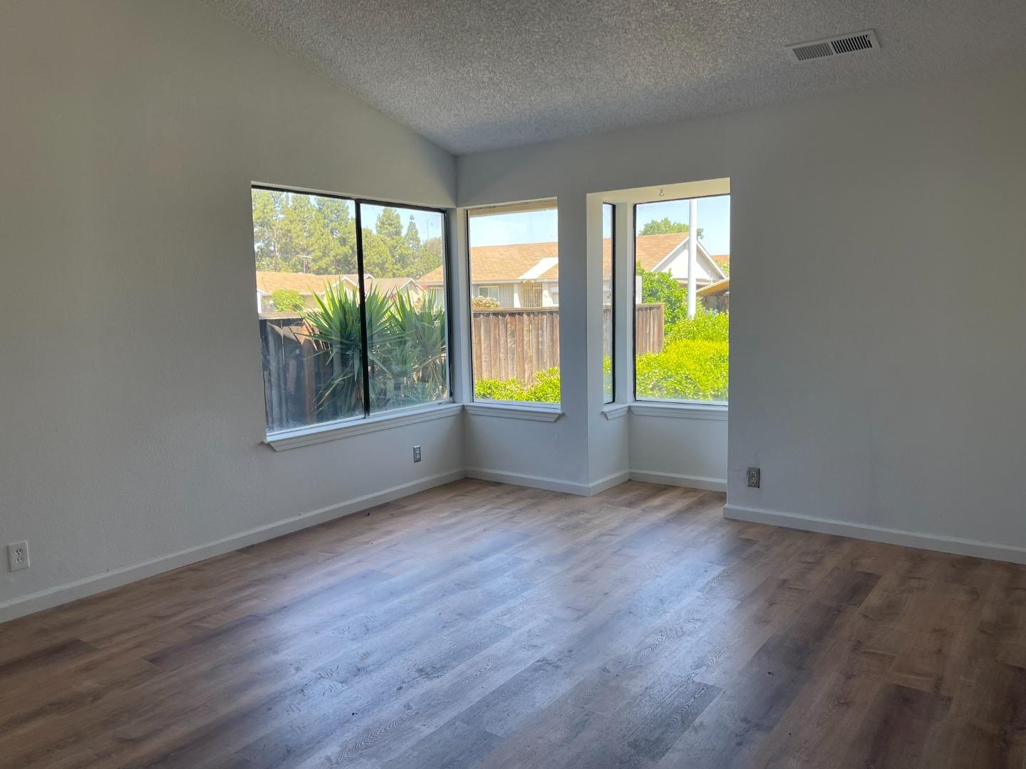 1363 Moonlight Circle Milpitas, CA 95035 - Photo 5 of 20 an empty room with wooden floor and windows