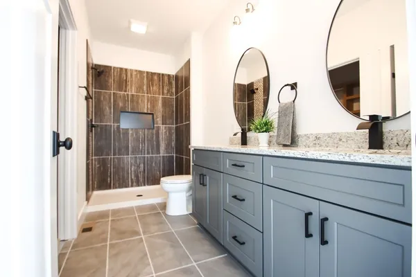 a bathroom with a double vanity sink mirror and bathtub