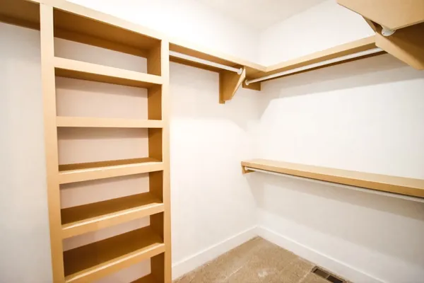 a view of walk in closet with empty racks