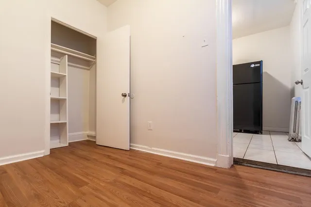 an empty room with wooden floor and closet