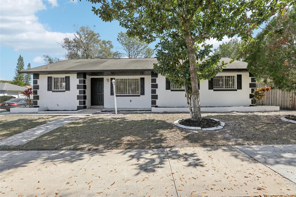 4425 Signal Hill Road Orlando, FL 32808 - Photo 1 of 1 a front view of a house with garden and trees