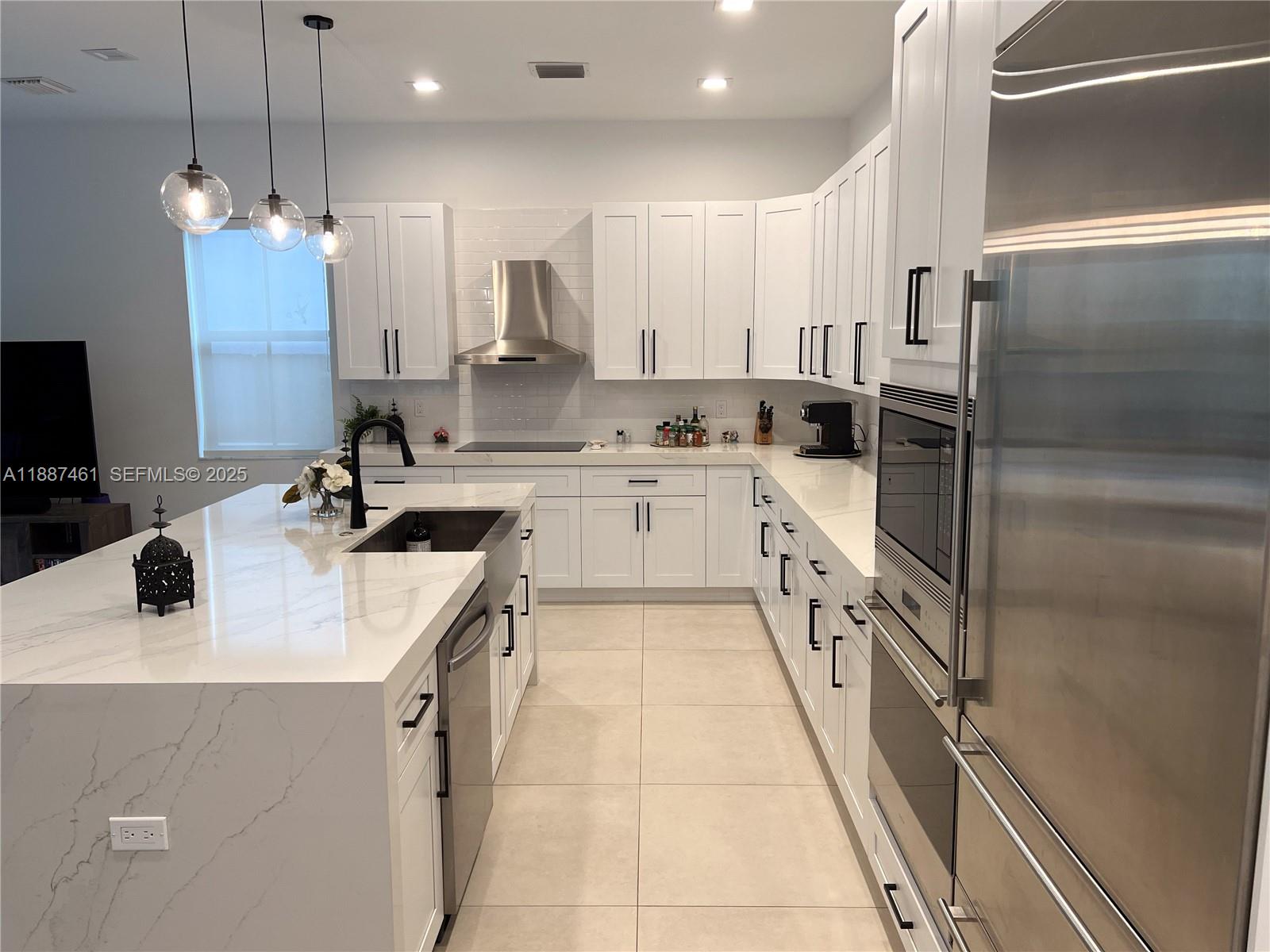 8904 Southwest 69th Trail Miami, FL 33173 - Photo 14 of 42 a kitchen with stainless steel appliances a sink stove and refrigerator