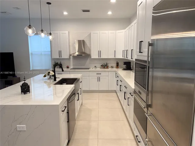 a kitchen with stainless steel appliances a sink stove and refrigerator