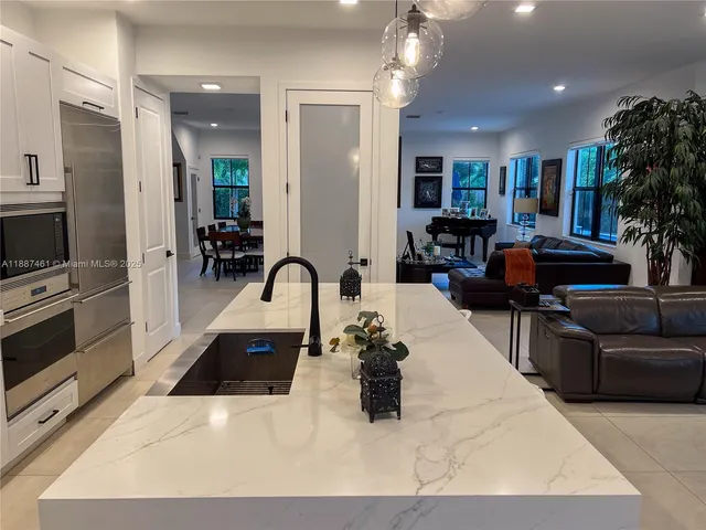 a kitchen with stainless steel appliances kitchen island granite countertop a couch and cabinets