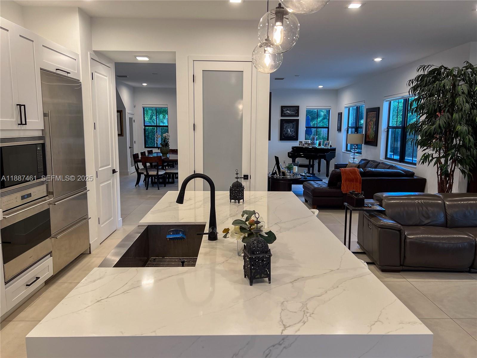 8904 Southwest 69th Trail Miami, FL 33173 - Photo 18 of 42 a kitchen with stainless steel appliances kitchen island granite countertop a couch and cabinets