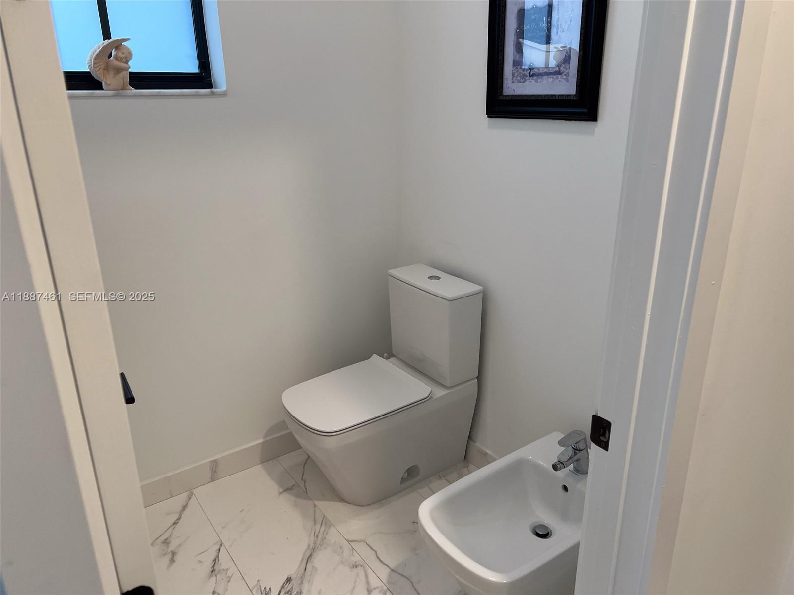 8904 Southwest 69th Trail Miami, FL 33173 - Photo 32 of 42 a white toilet sitting next to a bathroom sink