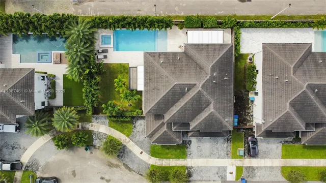 an aerial view of residential houses with outdoor space and trees