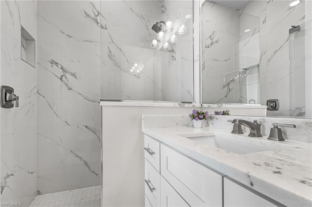 855 Lagoon Street, Unit 4 Fort Myers Beach, FL 33931 - Photo 25 of 40 a bathroom with double vanity sink and a mirror