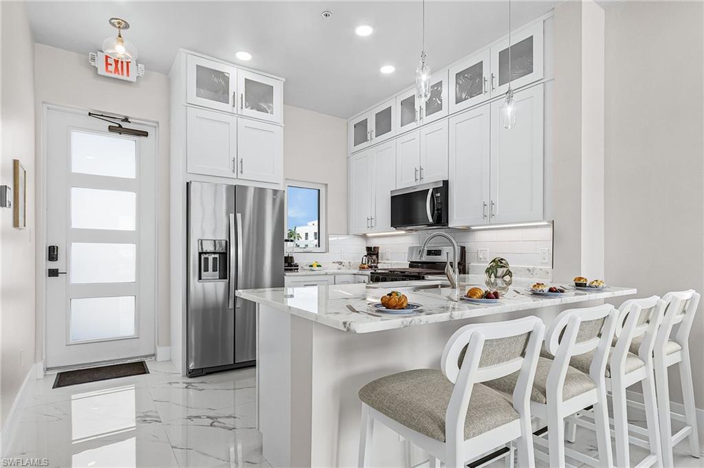 855 Lagoon Street, Unit 4 Fort Myers Beach, FL 33931 - Photo 26 of 40 a kitchen with stainless steel appliances a refrigerator sink and microwave