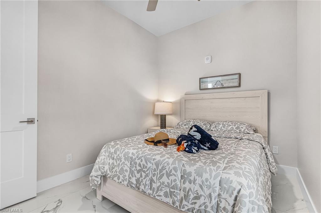 855 Lagoon Street, Unit 4 Fort Myers Beach, FL 33931 - Photo 31 of 40 a bedroom with a bed and a lamp on the dresser