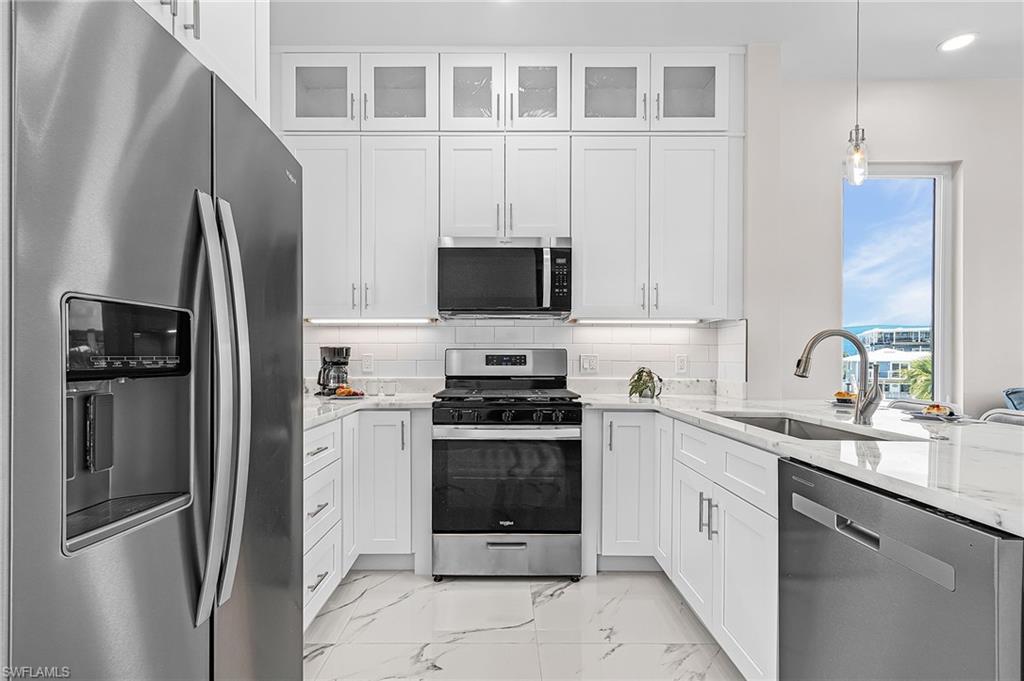 855 Lagoon Street, Unit 4 Fort Myers Beach, FL 33931 - Photo 32 of 40 a kitchen with stainless steel appliances granite countertop a refrigerator stove and sink