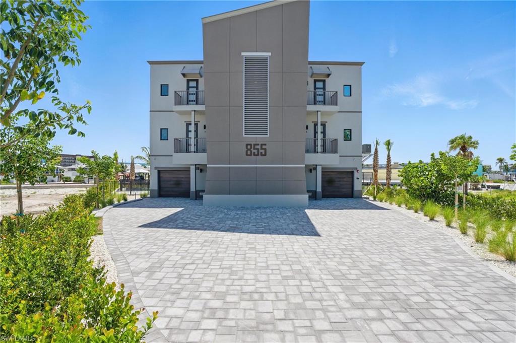 855 Lagoon Street, Unit 4 Fort Myers Beach, FL 33931 - Photo 9 of 40 a front view of a house with a yard