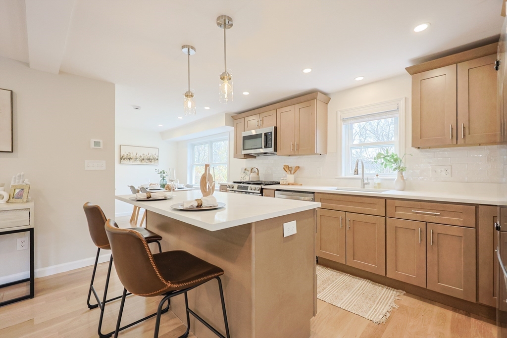 81 Elliott Street Danvers, MA 01923 - Photo 5 of 31 a kitchen with stainless steel appliances kitchen island granite countertop a sink a stove a dining table and chairs