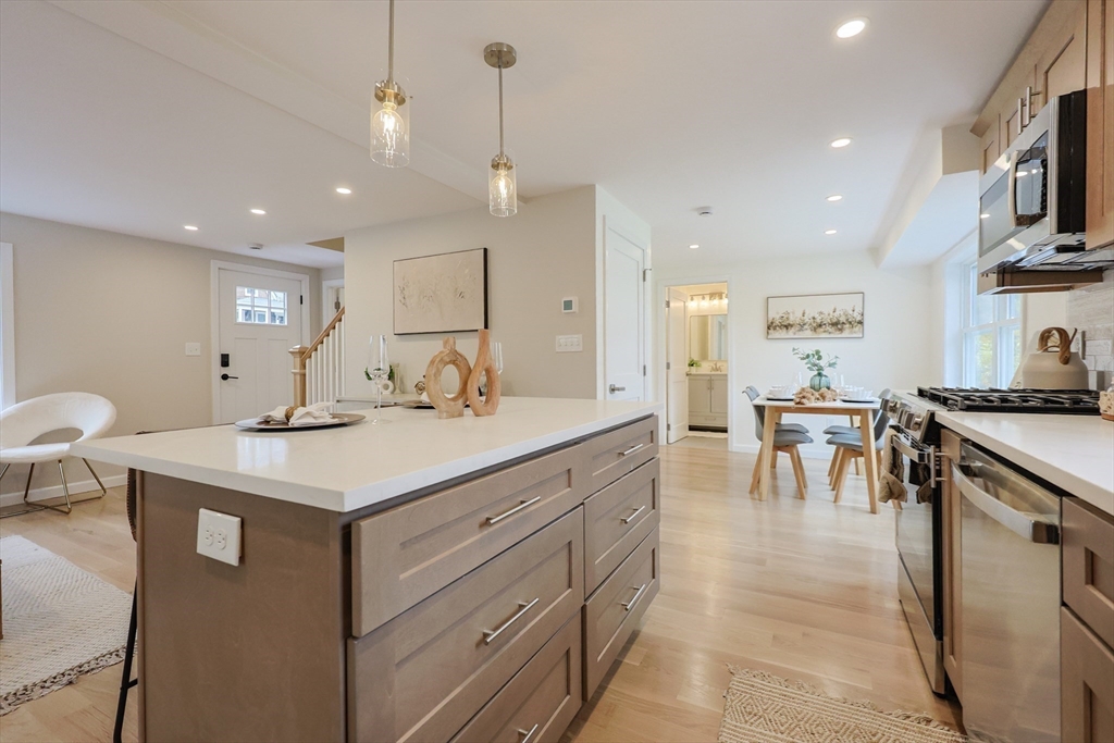 81 Elliott Street Danvers, MA 01923 - Photo 6 of 31 a kitchen with lots of counter space a sink appliances and a living room view