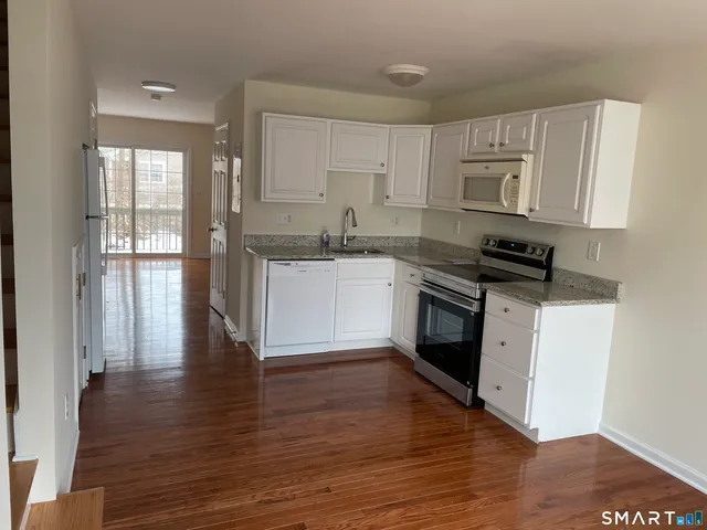 a kitchen with granite countertop a stove top oven and cabinets