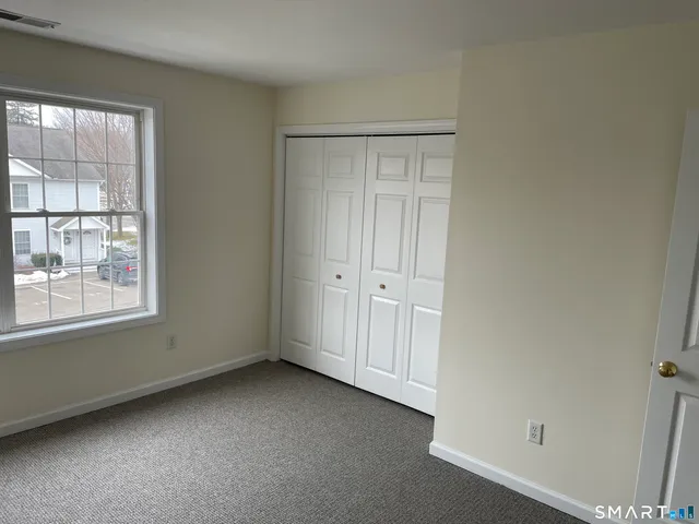 an empty room with windows and closet