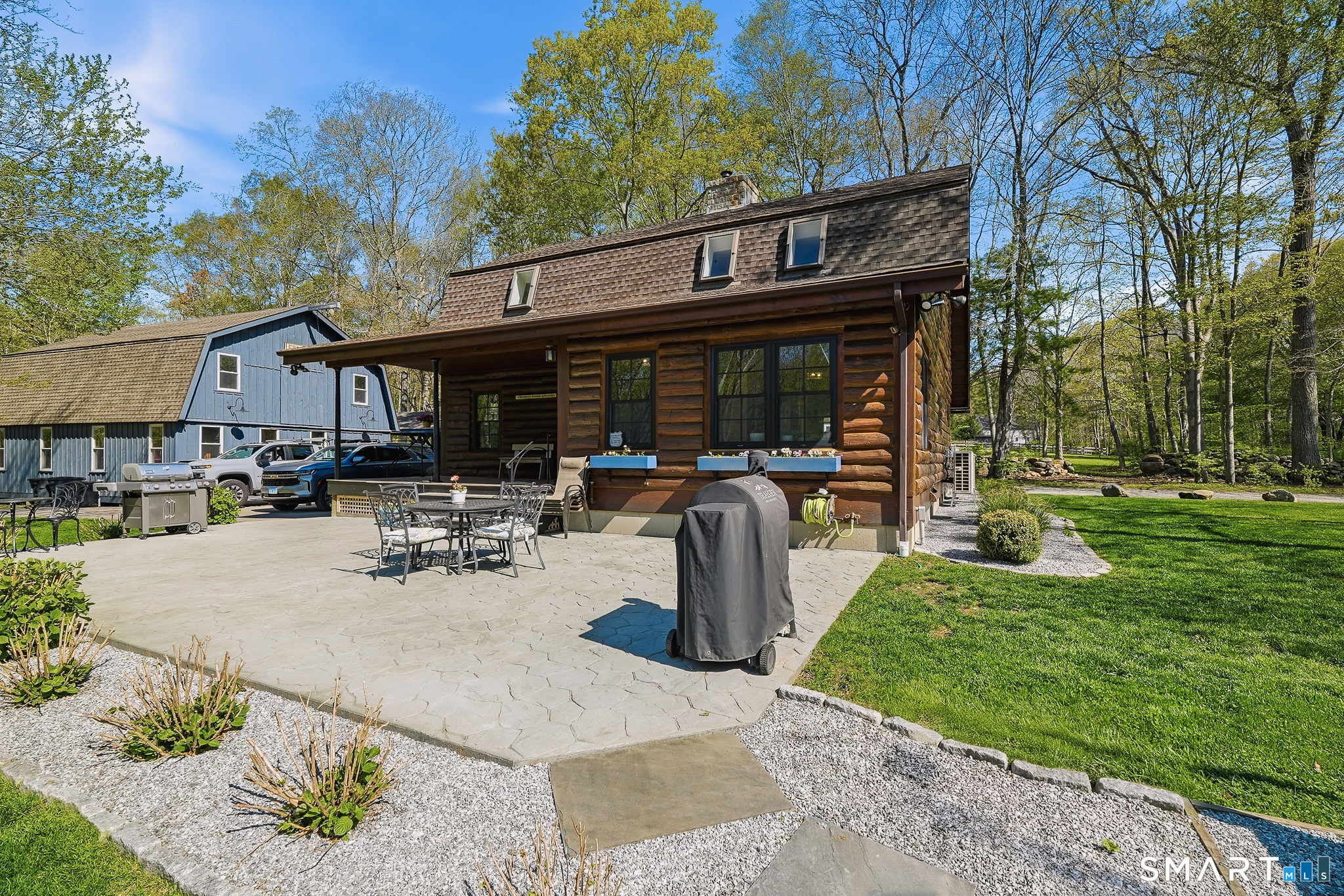 61 Mystic Road North Stonington, CT 06359 - Photo 31 of 40 a view of a patio with table and chairs potted plants and a large tree