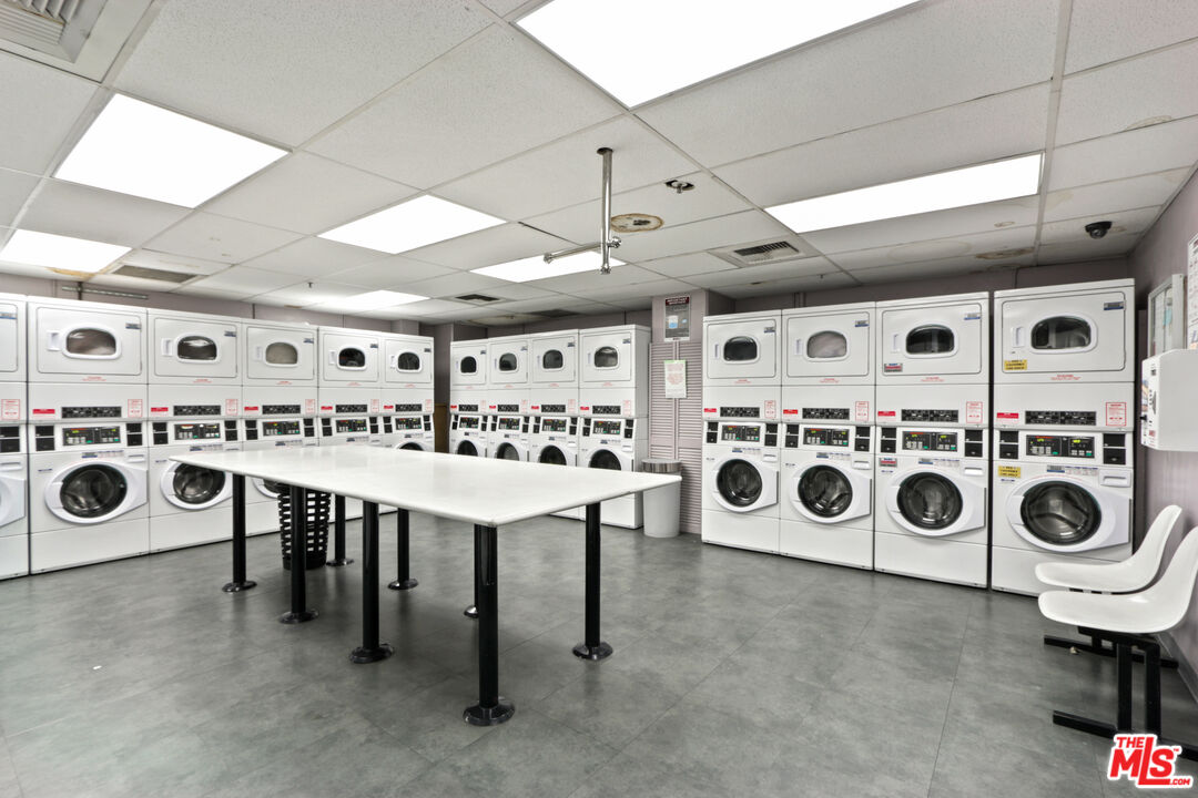 2160 Century Park, Unit 605 Los Angeles, CA 90067 - Photo 18 of 18 a utility room with stainless steel appliances a white stove top oven a sink a washer and dryer next to a window