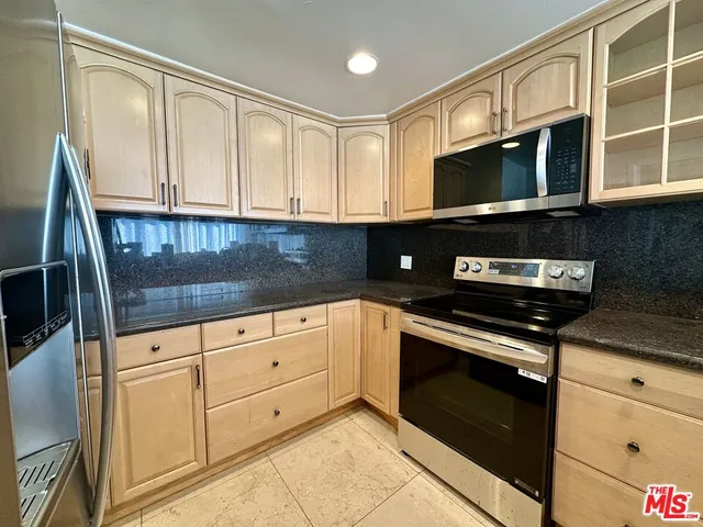 a kitchen with stainless steel appliances granite countertop cabinets and a microwave oven