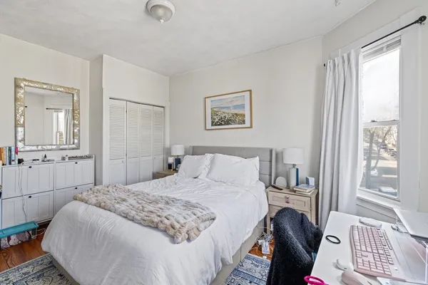 a bedroom with a bed and wooden floor